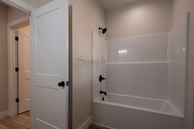 bathroom featuring hardwood / wood-style flooring and  shower combination