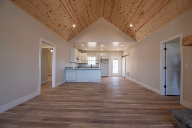 kitchen featuring wood ceiling, a barn door, light hardwood / wood-style floors, and white cabinets