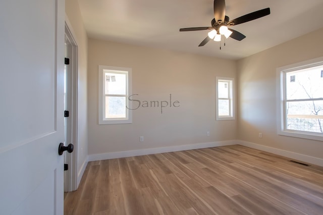 empty room with ceiling fan and light hardwood / wood-style flooring