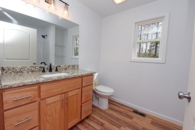 bathroom with wood-type flooring, vanity, toilet, and walk in shower