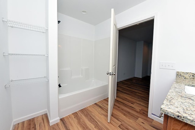 bathroom featuring hardwood / wood-style floors, vanity, and bathtub / shower combination