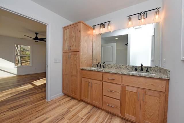 bathroom featuring ceiling fan, wood-type flooring, and vanity