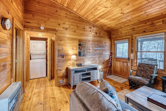 57 Coffee Pot Dr, Blue Ridge, GA 30513 - living room featuring stacked washer / dryer, vaulted ceiling, heating unit, wooden walls, and light wood-style floors