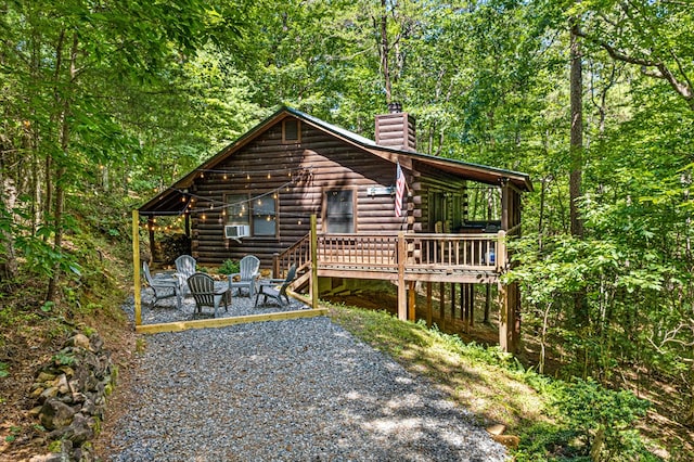 57 Coffee Pot Dr, Blue Ridge, GA 30513 - cabin with log siding, a chimney, a deck, a patio area, and a wooded view