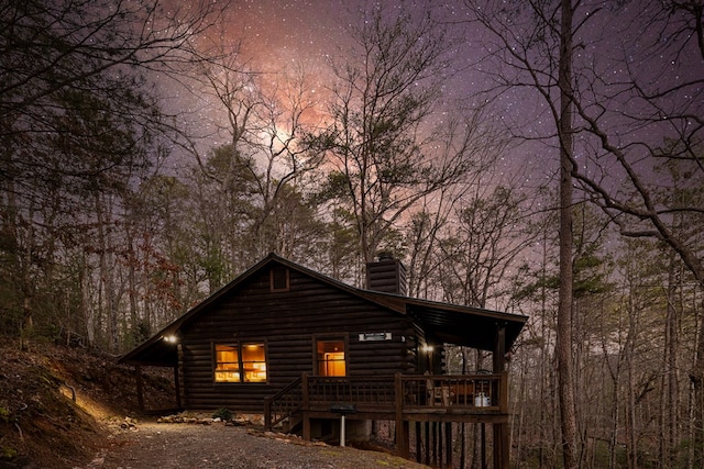 57 Coffee Pot Dr, Blue Ridge, GA 30513 - property exterior at dusk with a chimney, log exterior, and a porch