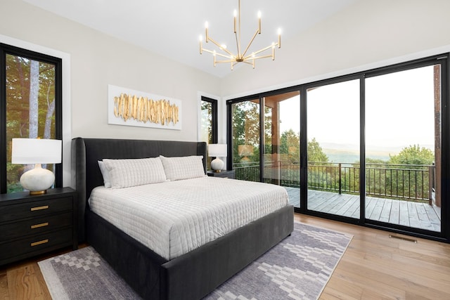 bedroom featuring a notable chandelier, access to exterior, and light hardwood / wood-style floors