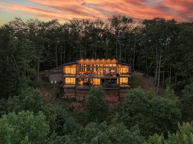 back house at dusk with a wooden deck