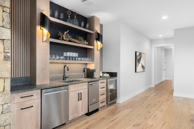 bar featuring sink, wine cooler, stainless steel dishwasher, light hardwood / wood-style floors, and light brown cabinets