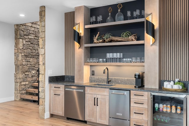 bar featuring wine cooler, light brown cabinetry, sink, light wood-type flooring, and stainless steel dishwasher