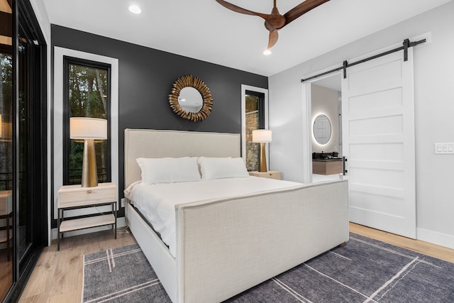 bedroom featuring a barn door and hardwood / wood-style floors