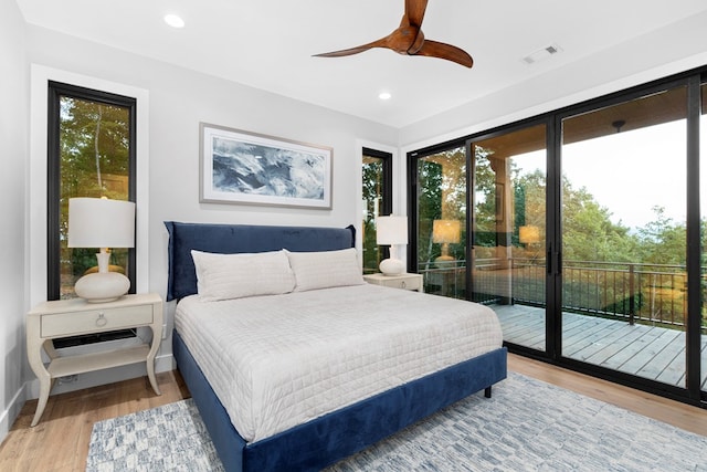 bedroom featuring ceiling fan, light hardwood / wood-style floors, multiple windows, and access to outside