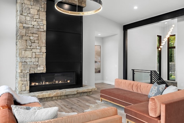 living room featuring wood-type flooring, a large fireplace, and vaulted ceiling