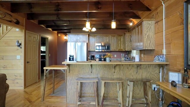 kitchen with wood ceiling, a stone fireplace, wood walls, and plenty of natural light