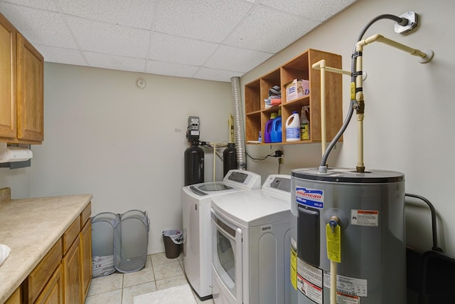 laundry room with cabinets, water heater, light tile patterned floors, and washing machine and dryer