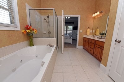 bathroom featuring independent shower and bath, tile patterned flooring, and vanity