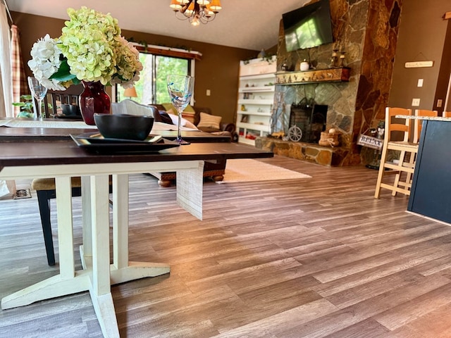 149 Poormans Trl, Murphy, NC 28906 - living area with a chandelier, wood finished floors, a stone fireplace, and vaulted ceiling