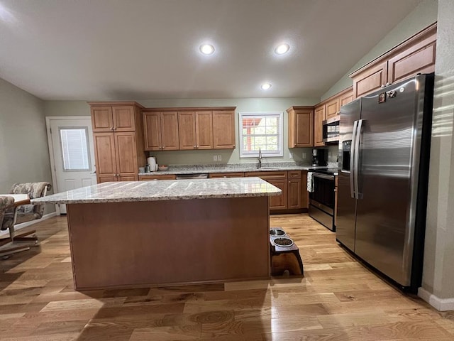 kitchen featuring stainless steel appliances, light hardwood / wood-style flooring, and a kitchen island