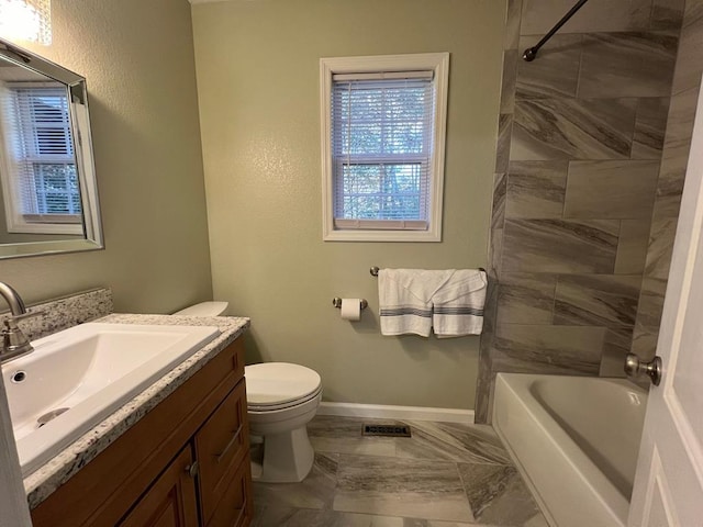 full bathroom featuring toilet, tiled shower / bath combo, and vanity