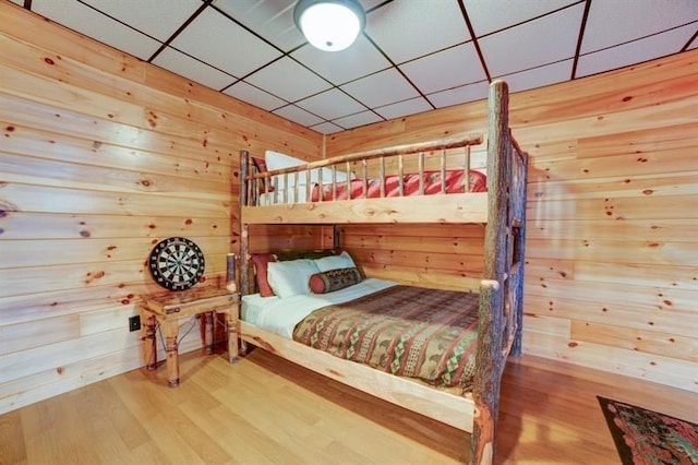 bedroom featuring wood walls and wood finished floors