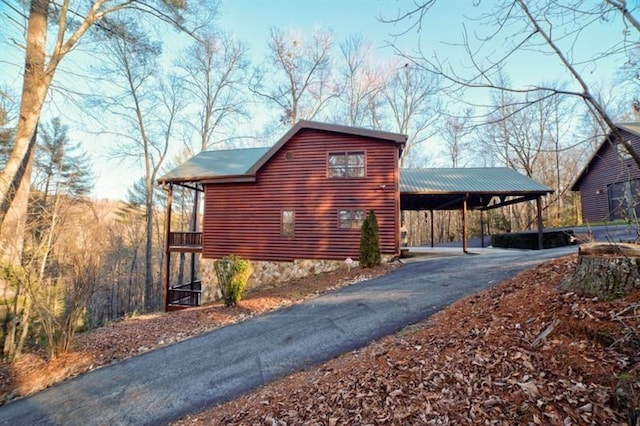 view of side of property with aphalt driveway and an attached carport