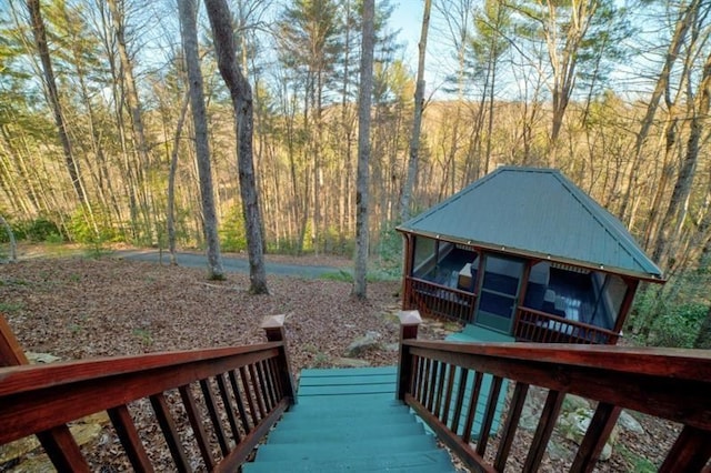 deck with a sunroom and a forest view