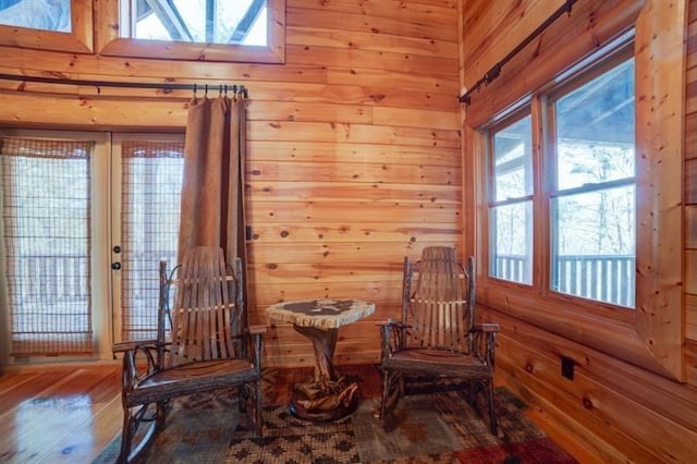 living area with wood walls, wood finished floors, a wealth of natural light, and a skylight