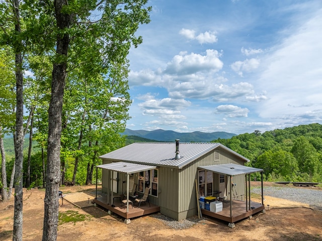 rear view of property with a deck with mountain view