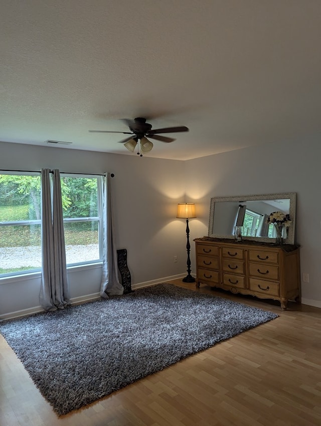 unfurnished bedroom with ceiling fan and hardwood / wood-style floors