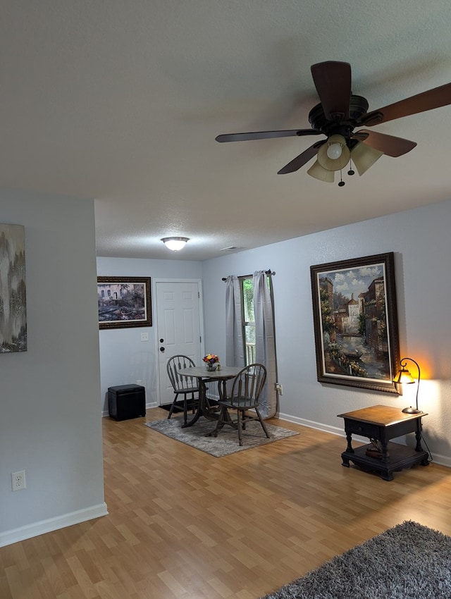 dining space with ceiling fan and light hardwood / wood-style flooring