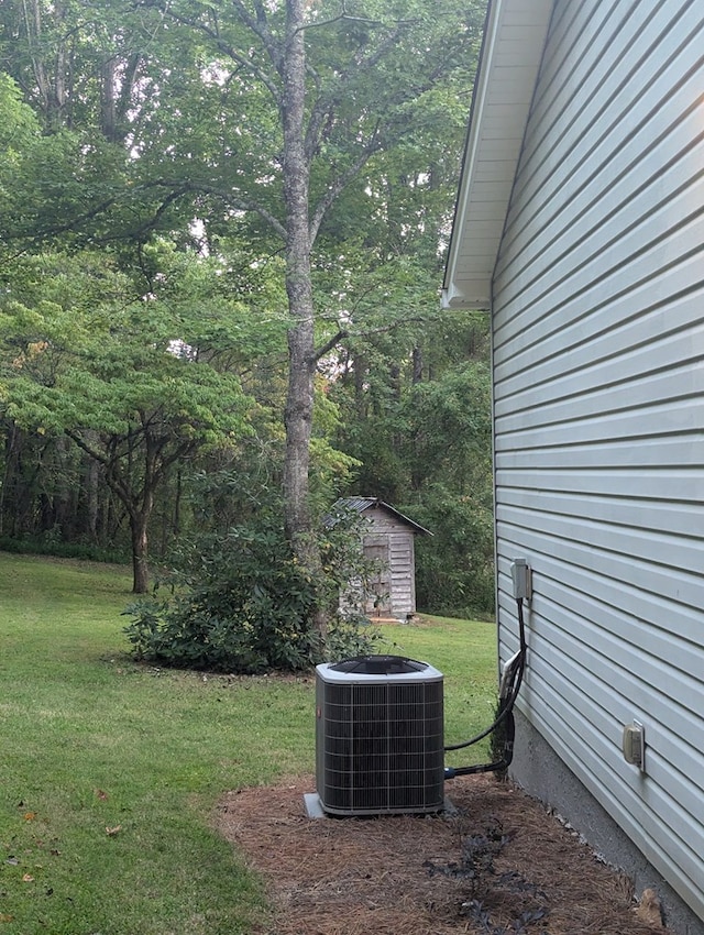 view of yard with central AC and a storage shed