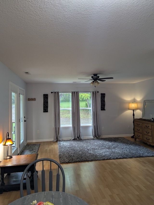 living room featuring a textured ceiling, light hardwood / wood-style flooring, and a healthy amount of sunlight