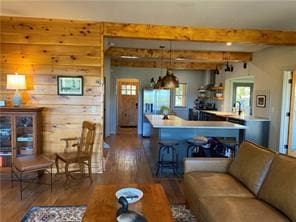 living room featuring beamed ceiling and dark hardwood / wood-style floors