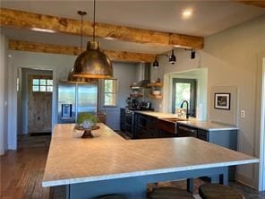 kitchen featuring a breakfast bar area, pendant lighting, beamed ceiling, sink, and stainless steel fridge with ice dispenser