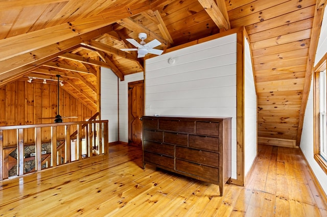 additional living space with vaulted ceiling with beams, wood ceiling, wood-type flooring, and wood walls