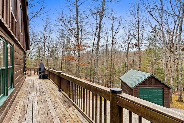 wooden deck featuring a forest view and an outbuilding