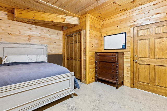 carpeted bedroom featuring a closet, wooden walls, and wood ceiling