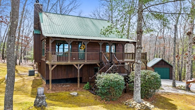 rustic home featuring an outbuilding, stairway, covered porch, a chimney, and metal roof