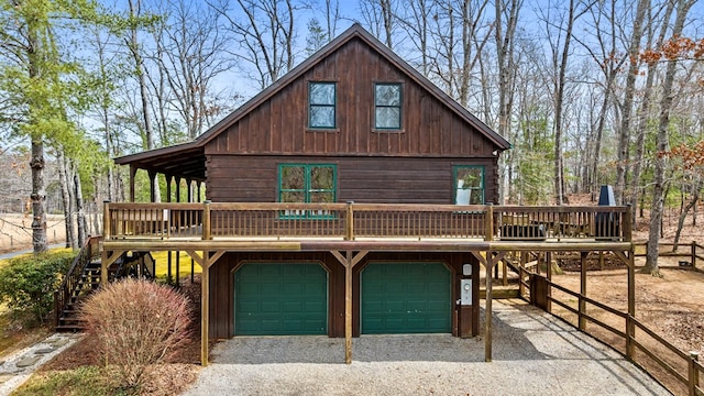 view of front of home featuring a wooden deck, gravel driveway, and a garage