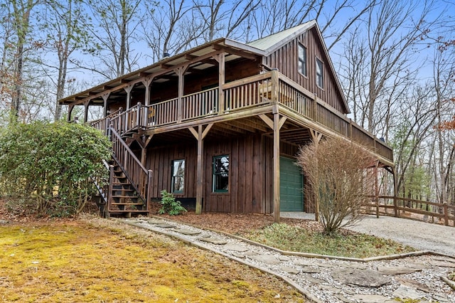 view of front of home with stairway, board and batten siding, and driveway