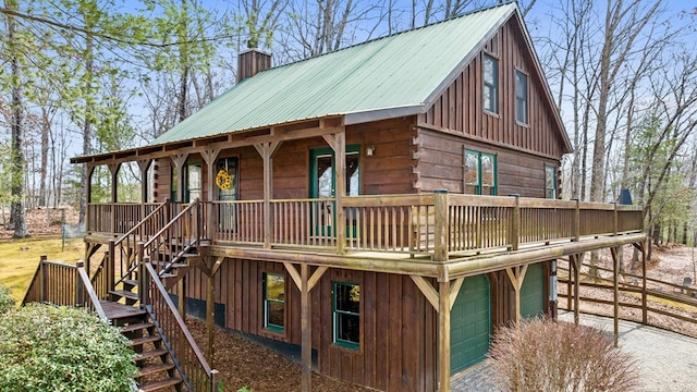 exterior space with stairway, metal roof, covered porch, and a chimney