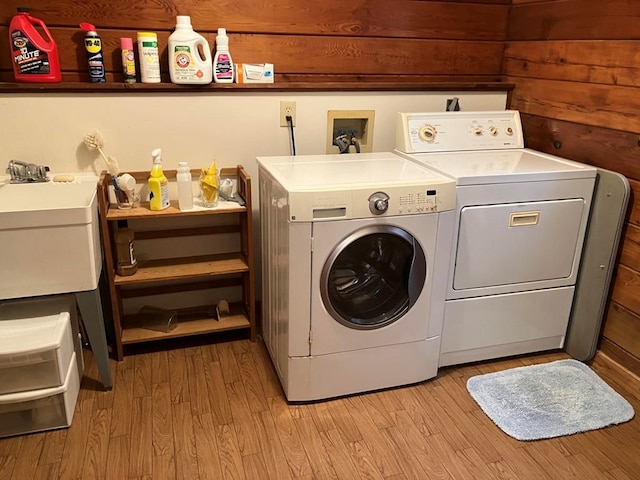 147 Holly Ridge Ln, Murphy, NC 28906 - laundry room with washing machine and dryer, sink, wooden walls, and light hardwood / wood-style flooring