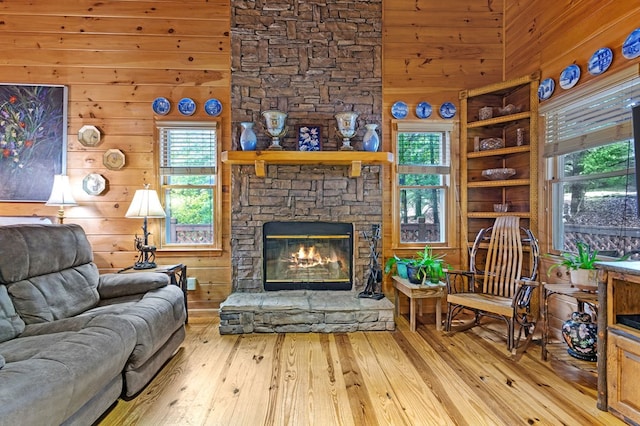 80 Stegall Mill Rdg, Ellijay, GA 30536 - living area with hardwood / wood-style floors, plenty of natural light, a stone fireplace, and wooden walls