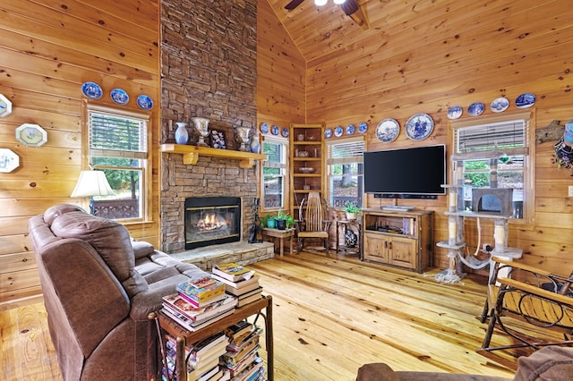 80 Stegall Mill Rdg, Ellijay, GA 30536 - living room with high vaulted ceiling, wooden walls, a stone fireplace, hardwood / wood-style flooring, and ceiling fan