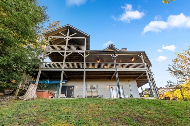 rear view of house with ceiling fan and a yard