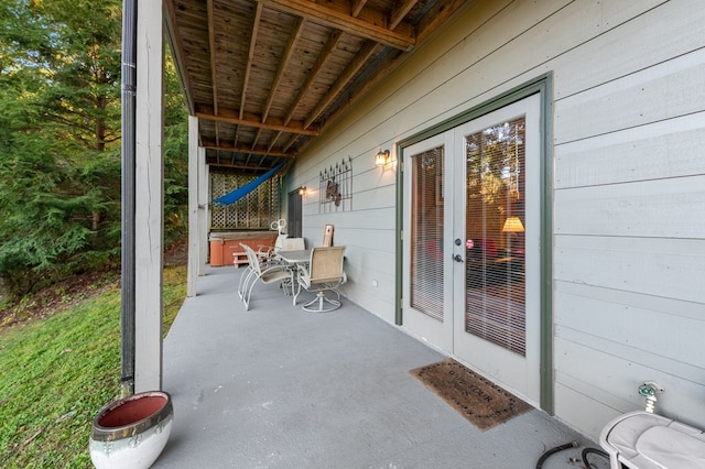 view of patio with a hot tub and french doors