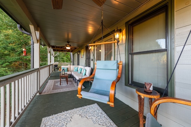 wooden deck with covered porch, ceiling fan, and an outdoor hangout area