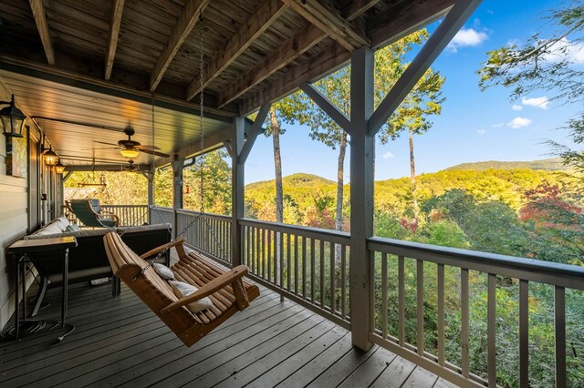 wooden deck featuring ceiling fan and a mountain view