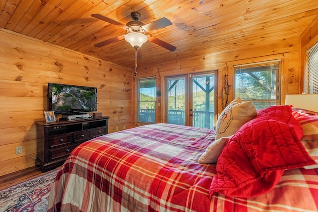 bedroom with wood walls, wood ceiling, ceiling fan, and access to outside