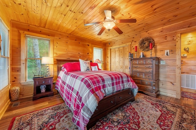 bedroom with wood ceiling, ceiling fan, wooden walls, and hardwood / wood-style flooring