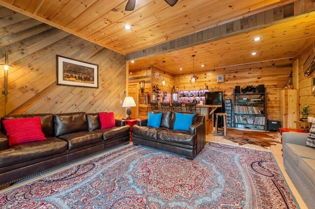 living room featuring wooden ceiling, wooden walls, and ceiling fan